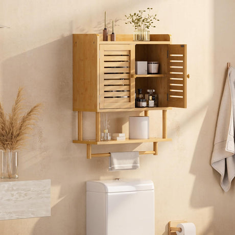 AmazerBath natural bamboo wall cabinet installed above a toilet with towels, toiletries, and decor stored inside.