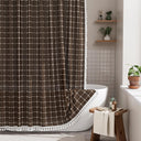 AmazerBath brown grid linen shower curtain: a grid curtain with white tassel trim hangs beside a bathtub in a bright bathroom.