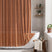 AmazerBath burnt orange striped linen curtain: orange fabric and white tassel trim frame a bathtub in a bright bathroom.