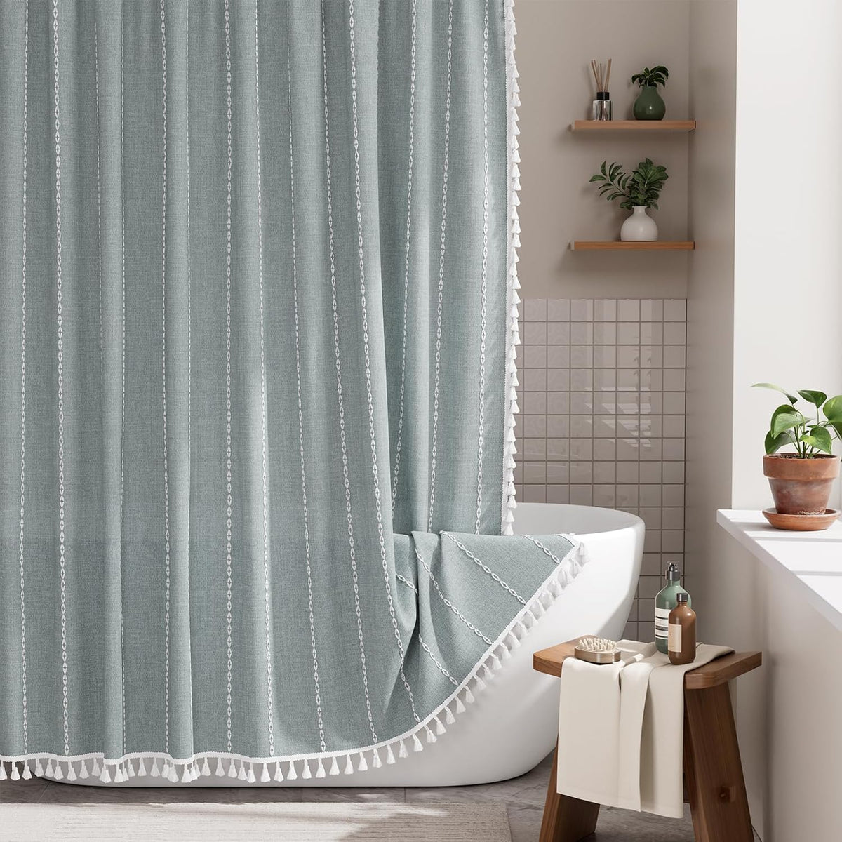 AmazerBath fog blue striped linen curtain: striped fabric and white tassel trim frame a bathtub in a bright bathroom.