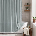 AmazerBath fog blue striped linen curtain: striped fabric and white tassel trim frame a bathtub in a bright bathroom.