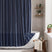 AmazerBath navy blue striped linen curtain: striped fabric and white tassel trim frame a bathtub in a bright bathroom.