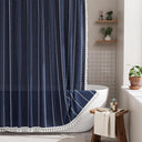AmazerBath navy blue striped linen curtain: striped fabric and white tassel trim frame a bathtub in a bright bathroom.