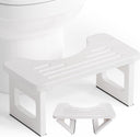 AmazerBath white foldable bamboo toilet stool: the compact folding stool rests in front of a toilet with its support legs visible.