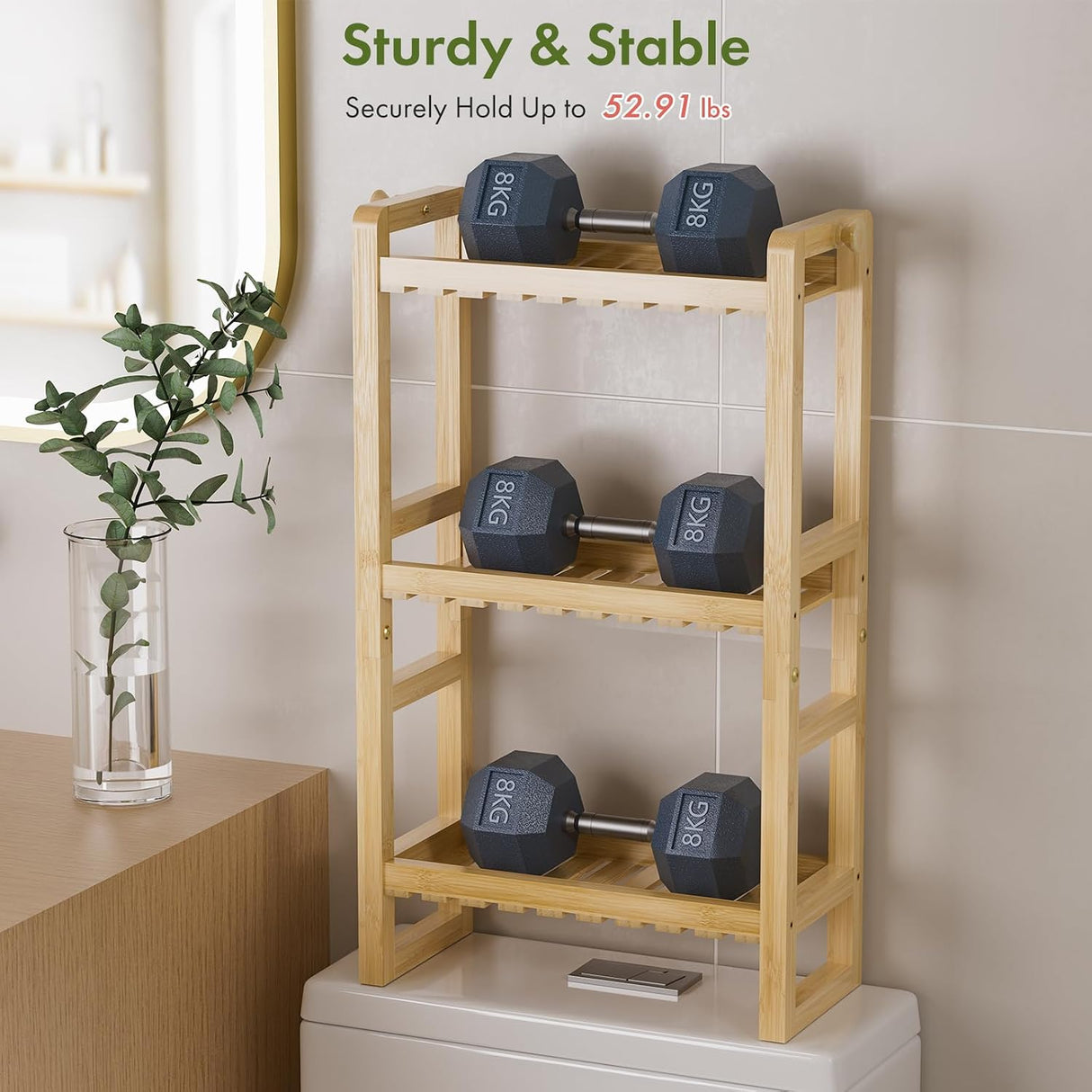 AmazerBath Natural bamboo over-the-toilet rack supporting dumbbells across three shelves to demonstrate its 52.91-pound capacity.