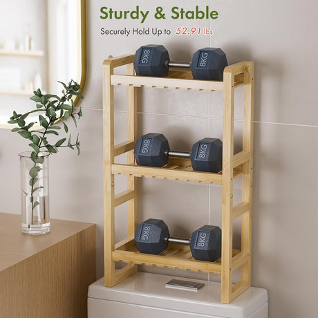 AmazerBath Natural bamboo over-the-toilet rack supporting dumbbells across three shelves to demonstrate its 52.91-pound capacity.