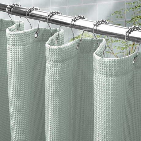 AmazerBath Grayish Green waffle shower curtain with a folded top hem, textured fabric, metal grommets, and hooks on a rod.